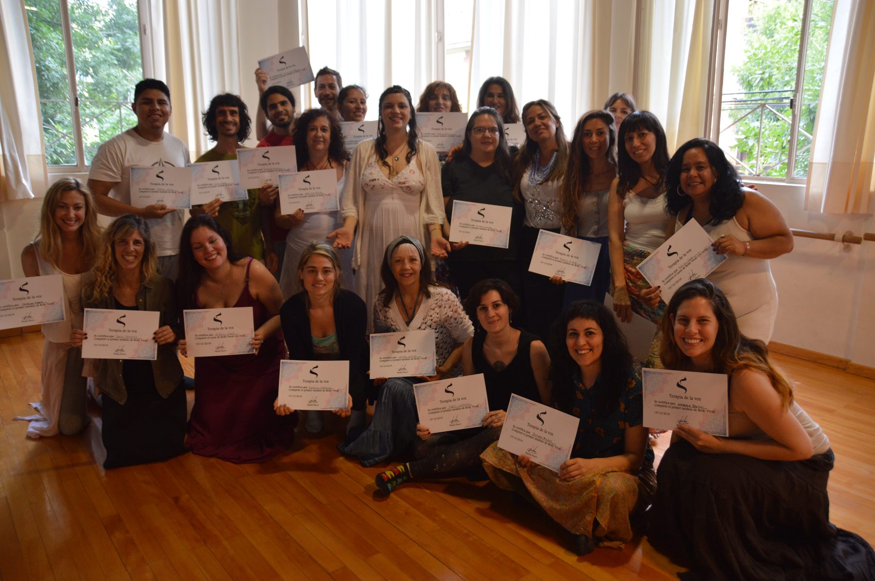 Grupo completo sosteniendo sus certificados al finalizar el curso